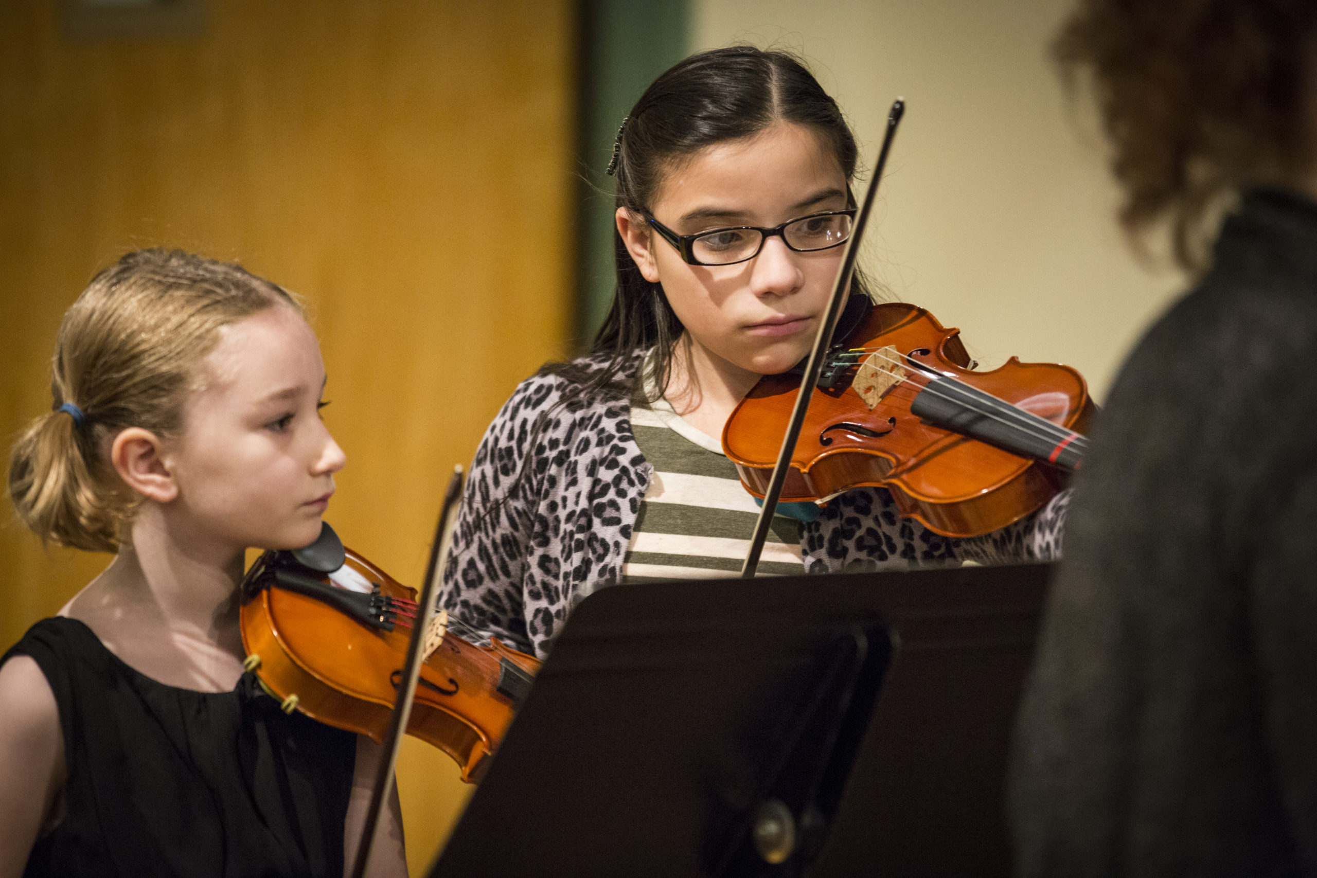 two elementary age students playing violin