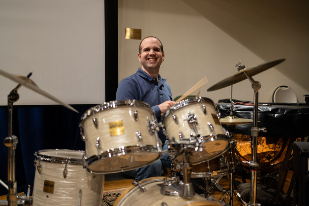 An adult student playing the drums.