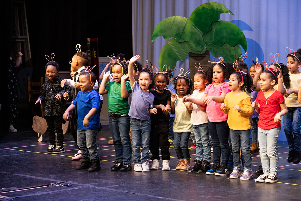 Kids singing on a stage.