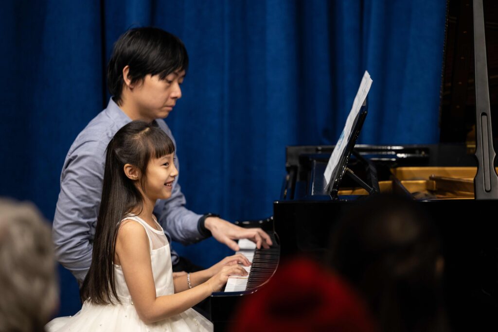A girl and a man playing the piano.